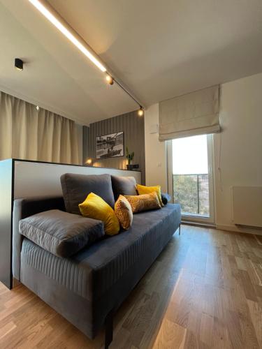a living room with a couch with yellow pillows at Halo Apartments in Wrocław
