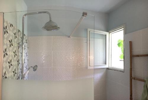 a bathroom with a shower with a glass door at Maison de charme en bord de Mer in Le Barcarès