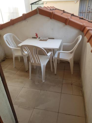 - une table et des chaises blanches dans la chambre dans l'établissement studio pour 3 personnes au calme dans villa, à Nice