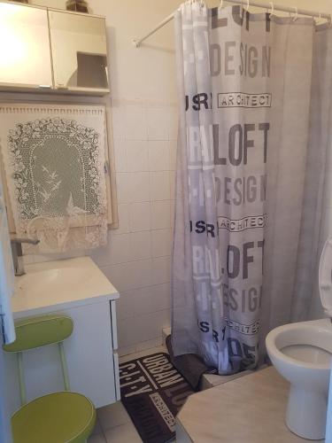 une salle de bain avec un rideau de douche et des toilettes dans l'établissement studio pour 3 personnes au calme dans villa, à Nice