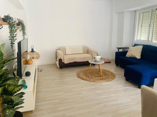 ein Wohnzimmer mit einem blauen Sofa und einem Tisch in der Unterkunft Calle oriente in Valencia