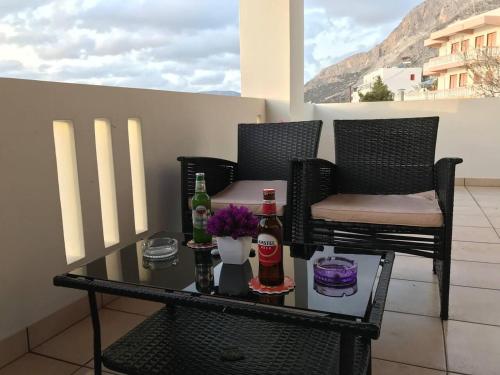 a table with two bottles and two chairs on a balcony at amazing apartment in the heart of masouri in Masouri