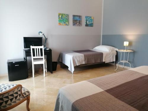 a bedroom with two beds and a desk with a computer at B&B AL PASSIO in Palermo