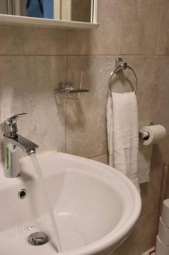 a bathroom with a white sink and a towel at Home Away From Home - 2 Bed FREE Parking & Wifi in Hunslet