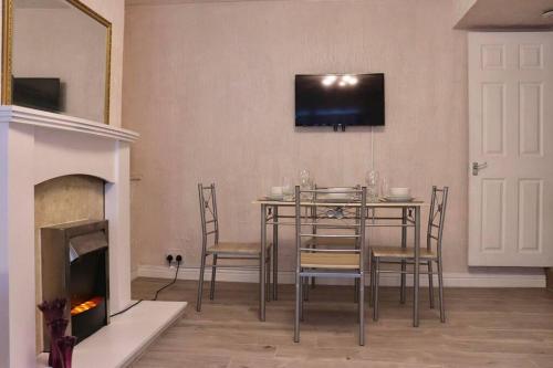 a dining room with a table and a fireplace at Home Away From Home - 2 Bed FREE Parking & Wifi in Hunslet