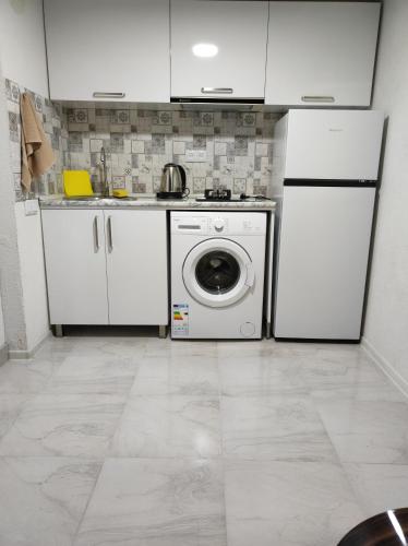 a kitchen with a refrigerator and a washing machine at Guest House Koba in Batumi