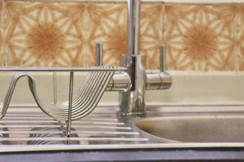 a kitchen sink with a metal rack next to a sink at Home Away From Home - 2 Bed FREE Parking & Wifi in Hunslet