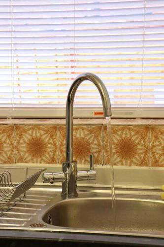 a kitchen sink with water pouring from a faucet at Home Away From Home - 2 Bed FREE Parking & Wifi in Hunslet