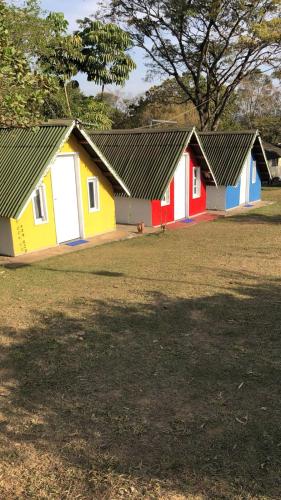 a row of colorful houses in a field at Pousada Sitio Roda D'Água Mairinque in Mairinque