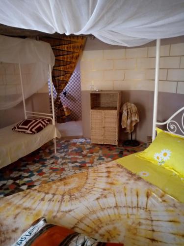 a bedroom with a bunk bed in a room at Campement Baobab chambres d'hotes 15mn de l'aeroport in Poponguine
