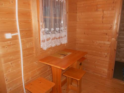 a small room with a wooden table and two stools at Artur´s Eaterie and Holiday home in Viitna