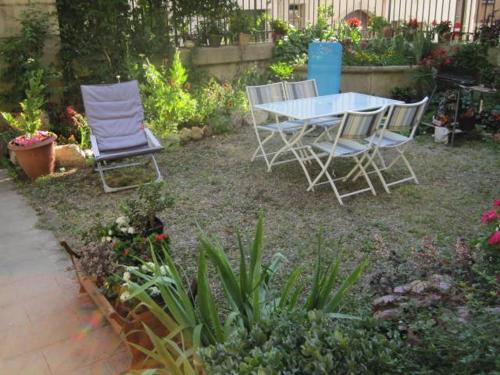 2 chaises et une table dans un jardin dans l'établissement Studio 30 m2 avec jardin dans maison de maître, à Béziers