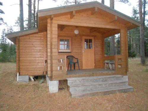 a small wooden cabin with a chair in it at Artur´s Eaterie and Holiday home in Viitna