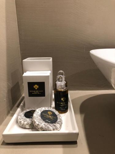 a white tray with a bottle of soap and a candle at Ai Propilei del Duomo Luxury Suite in Lecce