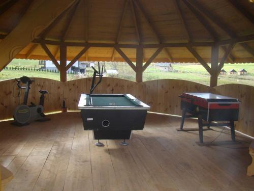 a room with a pool table and a piano at Rancho Zawóz domek nr5 in Zawóz