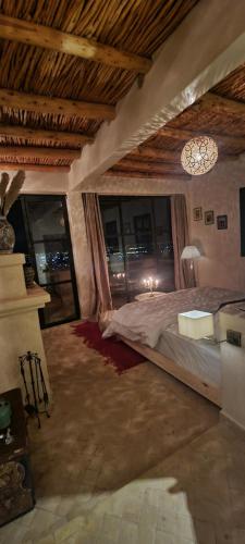 a bedroom with a large bed and a chandelier at ourika oufla in Ourika