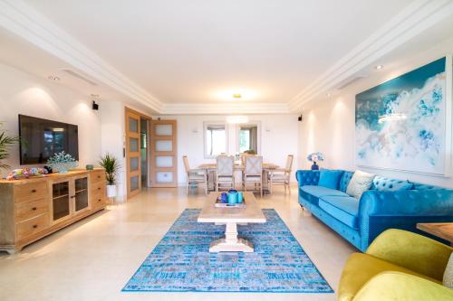 een woonkamer met een blauwe bank en een tafel bij MARBELLA BANUS SUITES - Golden Mile Jardines del Príncipe Suite Apartment in Marbella