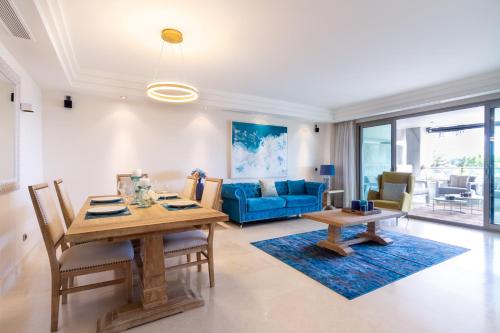 a living room with a table and a blue couch at MARBELLA BANUS SUITES - Golden Mile Jardines del Príncipe Suite Apartment in Marbella