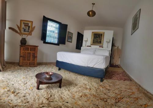 a bedroom with a bed and a table in it at ourika oufla in Ourika