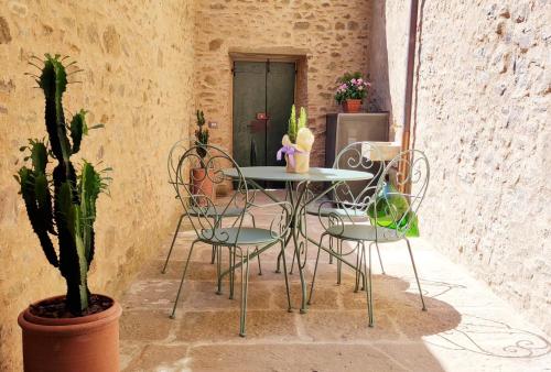 eine Terrasse mit einem Tisch, Stühlen und einer Pflanze in der Unterkunft Casa Primo in Cortona