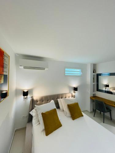 a bedroom with a large white bed with two pillows at Diamond Paradise in Le Diamant