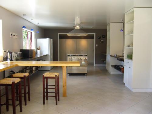a kitchen with a large wooden table and stools at Hopewell Lodge in Kenepuru Sounds
