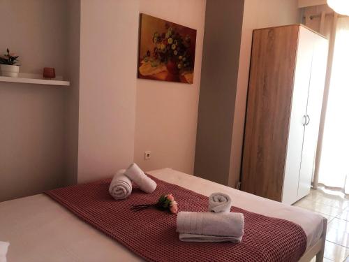 a bedroom with a bed with towels on it at Pink Rose Apartment in Nea Peramos