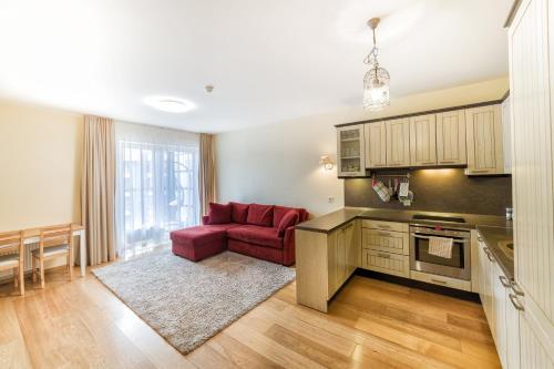 - une cuisine avec un canapé rouge dans le salon dans l'établissement Ona`s apartment in City Center with private parking, à Kaunas