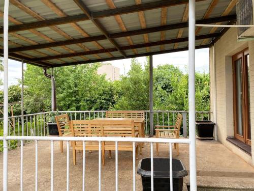 a porch with a wooden table and chairs at Wooden Museum in Kutaisi