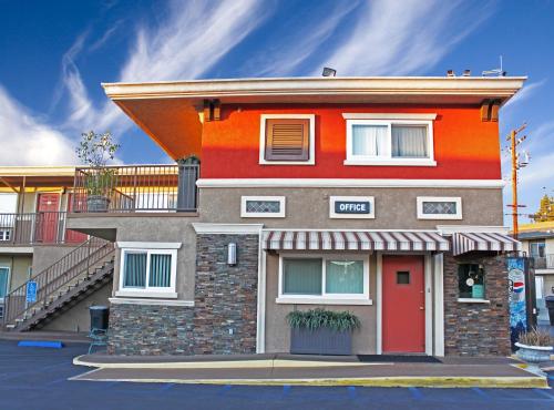 an orange building with a red door on a street at Friendly Hills Inn in Whittier