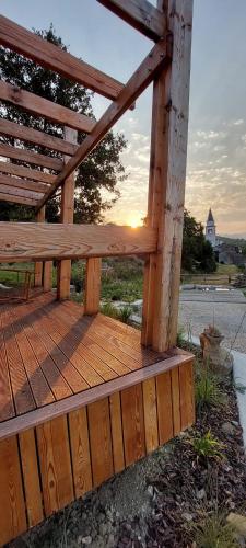 a wooden deck with the sun setting in the background at Panorama glamping Vipavska dolina in Dobravlje
