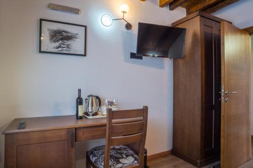 a room with a wooden desk with a television on the wall at Apartments-Rooms Stara Varos in Žabljak