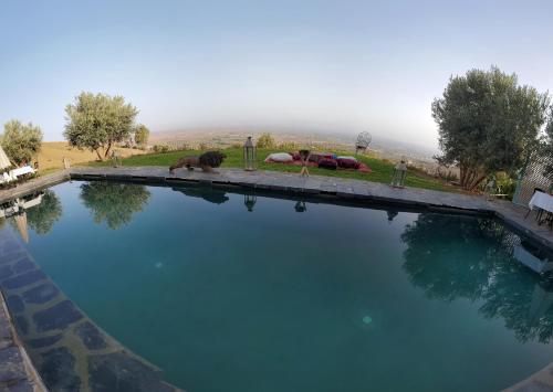 a large pool of water with two people laying on the ground at ourika oufla in Ourika