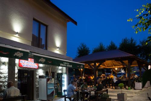 a group of people sitting at tables outside a restaurant at Apartments-Rooms Stara Varos in Žabljak