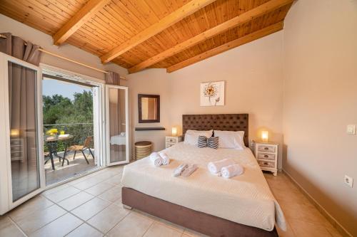 um quarto com uma cama grande e uma varanda em Popi's Villa em Svoronata