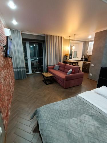 a hotel room with a bed and a couch at Квартира в центре города in Petropavlovsk