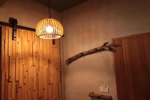 a room with a branch on the wall and a light at 以樂以樂 in Lugang