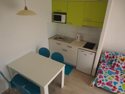 a small kitchen with a white table and chairs at Vila Snježana Tučepi in Tučepi