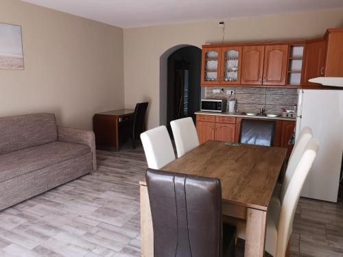a kitchen and living room with a table and a couch at Zöldház Panzió in Gyenesdiás