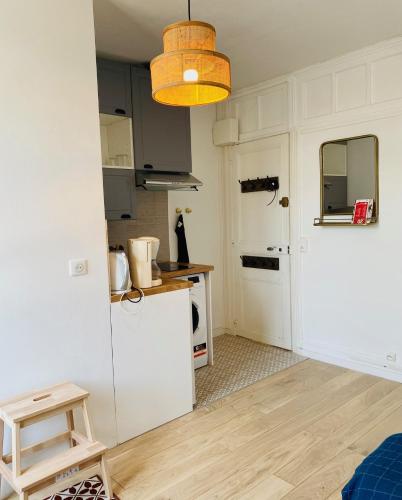 une cuisine avec un réfrigérateur blanc et une table dans l'établissement Joli Studio à Trouville, à Trouville-sur-Mer