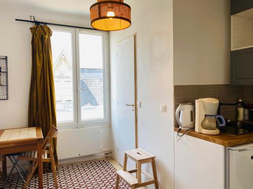 une cuisine avec une fenêtre, une table et un comptoir dans l'établissement Joli Studio à Trouville, à Trouville-sur-Mer