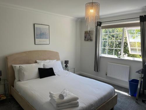 a bedroom with a white bed with towels on it at SleepNeat in Ascot
