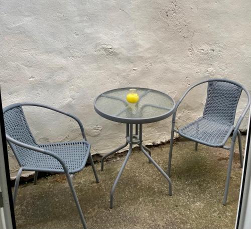 two chairs and a glass table with a bowl on it at Modern 2 Bedroom Ground Floor Apartment with Parking Ripon City Centre in Ripon