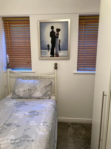 a bedroom with a bed and a picture of a couple at Modern 2 Bedroom Ground Floor Apartment with Parking Ripon City Centre in Ripon