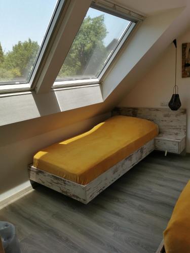 a bed in a room with two windows at Májusfa in Balatonszárszó