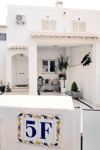 a white house with a sign that at Alojamento local "CASA BRANCA" in Albufeira