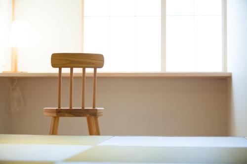 a wooden chair sitting in front of a window at Kinsui Annex in Toyooka