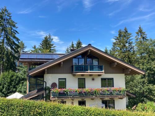 a house with a balcony with flowers on it at Haus Waldfrieden in Bischofswiesen