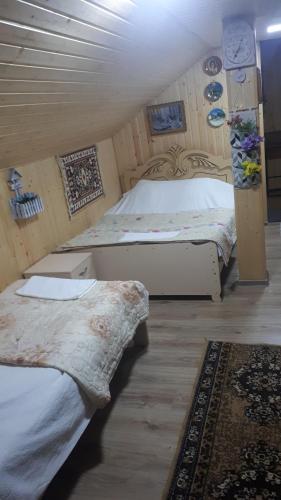 a bedroom with two beds and a rug at Holiday Home Racha in Ambrolauri