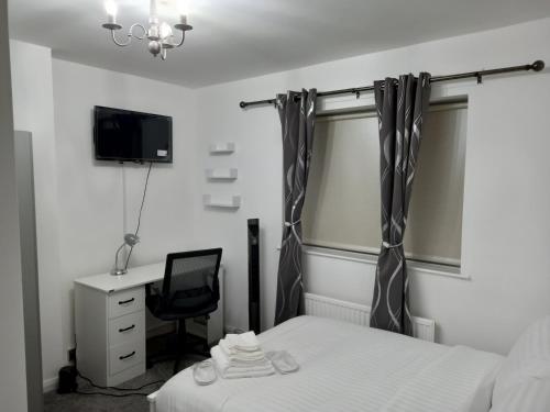 1 dormitorio con cama, escritorio y ventana en Garswood Road House, en Mánchester